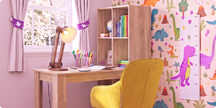 Quarto de estudo infantil luminoso com secretária de madeira, cadeira ergonómica amarela, candeeiro de secretária, prateleira de arrumação e papel de parede com dinossauros, ideal para criar um espaço de aprendizagem organizado e confortável em casa.
